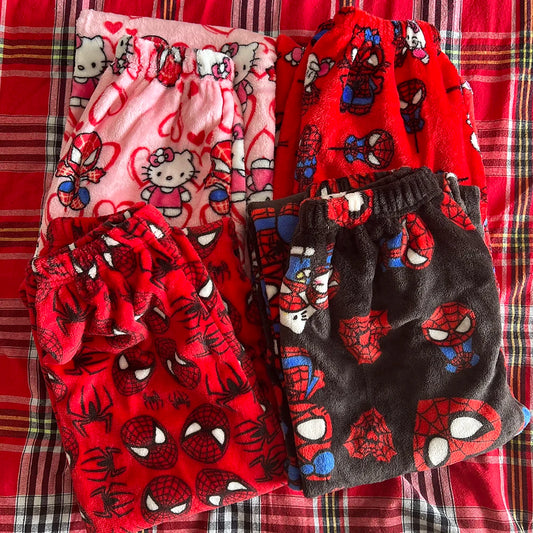 Four pairs of Hello Kitty Spider Pajama Pants arranged neatly. Each pair features a playful design with Hello Kitty’s face and spiderweb patterns, combining cute and spooky elements. The pants come in varying colors, including black, pink, and white, with a comfortable, loose fit ideal for lounging.